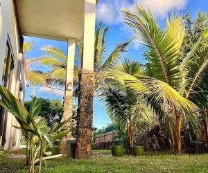 een gebouw met twee palmbomen ervoor bij Original Villa in Trou dʼ Eau Douce