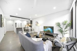 uma sala de estar com dois sofás e uma cozinha em Stay Steps from Olympic Park : Spacious 3-Bedroom em Sidney