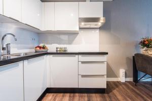 eine Küche mit weißen Schränken und einem Waschbecken in der Unterkunft YAYS Amsterdam North by Numa in Amsterdam