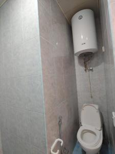 een kleine badkamer met een toilet en een tank bij Lahore Hotel Baku in Baku