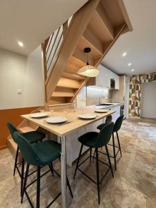 a kitchen with a large island with green chairs at Maison avec cour intérieure in Souillac