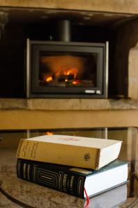 two books sitting on a table in front of a fireplace at Chambres d'hôtes - Le Mas du Colombeyras in Espeluche