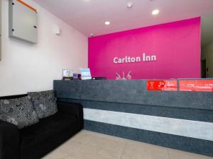 une salle d'attente avec un mur rose et un comptoir dans l'établissement OYO 89492 Carlton Inn Bukit Ubi, à Kuantan