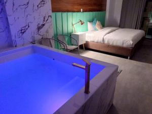 een hotelkamer met een bad met een bed en een bed bij Jacuzzi Hotel Cusco in Cuzco