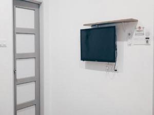 a television hanging on a wall next to a door at OYO 89492 Carlton Inn Bukit Ubi in Kuantan