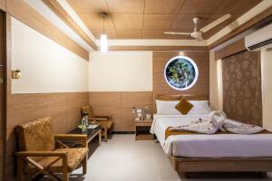 1 dormitorio con 2 camas, mesa y sillas en Sree Bharani Hotels, en Tirunelveli