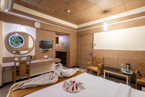 a hotel room with two beds and a tv at Sree Bharani Hotels in Tirunelveli