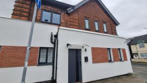 a white house with a black door and a brick building at Glamour no2 Flat in Mansfield +5 photos