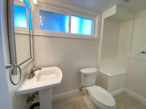 a bathroom with a toilet and a sink and a window at Entire Basement Apartment in Mississauga, Etobicoke in Mississauga