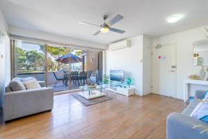 a living room with a couch and a table at Fleetwood 3 63 Shoal Bay Road Relaxed living with water views overlooking Shoal Bay in Shoal Bay +18 photos