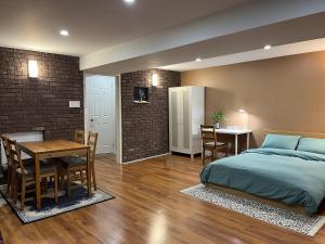 Entire Basement Apartment in Mississauga, Etobicoke في ميسيساوغا: غرفة نوم مع سرير وغرفة طعام مع طاولة