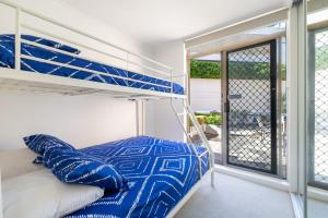 a bedroom with a bunk bed and a balcony at Fleetwood 3 63 Shoal Bay Road Relaxed living with water views overlooking Shoal Bay in Shoal Bay