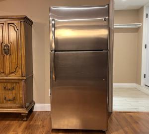 a stainless steel refrigerator in a kitchen next to a cabinet at Entire Basement Apartment in Mississauga, Etobicoke in Mississauga