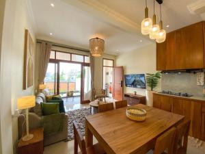uma cozinha e sala de estar com uma mesa de madeira em Siji Nayan Vacation Home em Yogyakarta