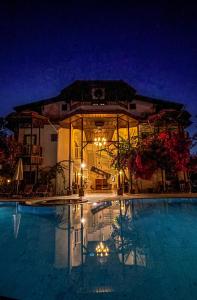 a building with a swimming pool at night at Murat Pasha Mansion in Dalyan