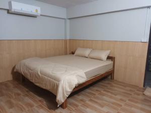 a bed in a room with a wooden floor at Noppakao Resort in Soem Ngam +11 photos