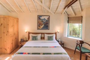 a bedroom with a large bed and a window at Tree of Life Birdsong Chalets , Dharamshala in Dharamshala