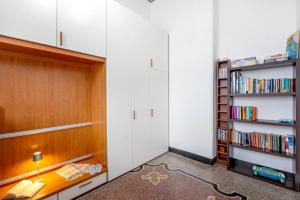 Zimmer mit weißen Wänden und Bücherregal in der Unterkunft Casa Olimpia in Savona