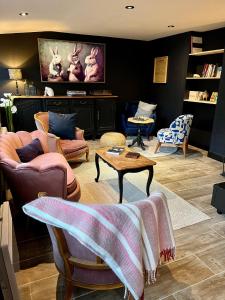 a living room with couches and a table and chairs at Hôtel Restaurant La Maison in Trébeurden