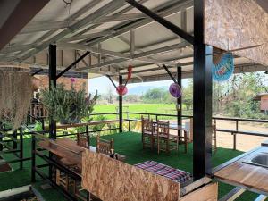 un patio con tavolo e sedie sotto una tenda. di Noppakao Resort a Soem Ngam