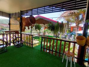 balcón con alfombra verde, mesa y sillas en Noppakao Resort, en Soem Ngam