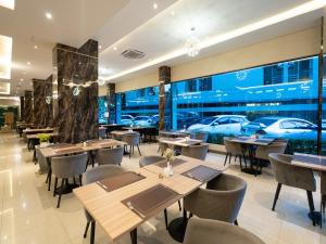 a restaurant with tables and chairs and cars in the window at Patong Bay Residence in Patong Beach
