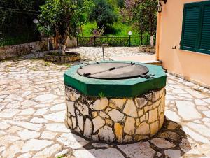 a statue of a clock on a stone patio at The Old Well, Spacious House in North Corfu in Perítheia