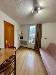 Una sala de estar con un sofá y una ventana grande. en Studio Pablotin d’Abriès, en Abriès