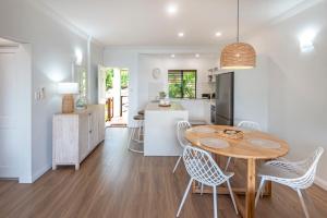 una cucina e una sala da pranzo con tavolo e sedie di Haven on Hamilton Island -private apartment with views & buggy Fully Renovated in 2023 a Hamilton Island