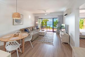 a living room with a couch and a table at Haven on Hamilton Island -private apartment with views & buggy Fully Renovated in 2023 in Hamilton Island