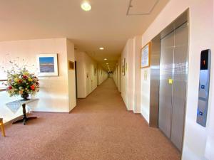 a hallway in a hospital with a vase of flowers at Hotel Lavenir in Biei