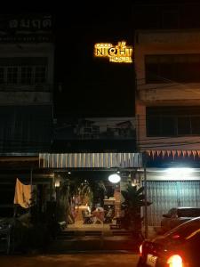 a night view of a hotel with a neon sign at Goodnighthostel@Trang in Trang