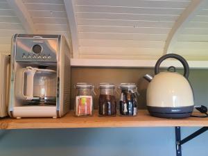 a counter with a toaster and jars on a shelf at Pipowagen het Sleephuis in Rohel