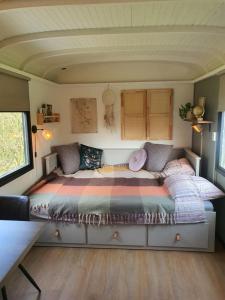 een bed in een kleine kamer in een tiny house bij Pipowagen het Sleephuis in Rohel