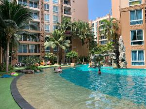 a pool at a hotel with people in the water at Atlantis Condominium Resort Pattaya in Jomtien Beach