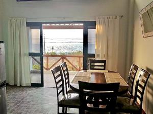 a dining room table and chairs with a view of the ocean at Casuarinas Del Mar Hospedaje Chalet 3 habitaciones in Canoas