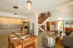a kitchen and a living room with a table and chairs at Aguada Anchorage - The Villa Resort, Candolim in Candolim