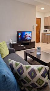 een woonkamer met een bank en een tv bij By The Way Apartment in Larnaka