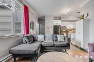 ein Wohnzimmer mit einem Sofa und einem Tisch in der Unterkunft L'Artiste - Chic conco avec piscine in Wendake