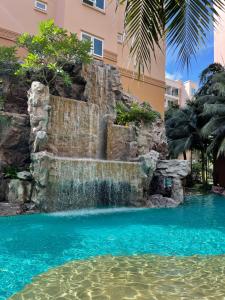 a waterfall in a pool with blue water at Atlantis Condominium Resort Pattaya in Jomtien Beach +38 photos