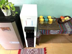 a white box next to a table with a coffee maker at Home Sol Guesthouse in Pantai Cenang
