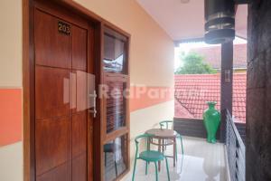 una habitación con una puerta y dos sillas y una mesa en Ndalem Pundhi Maguwoharjo RedPartner, en Seturan