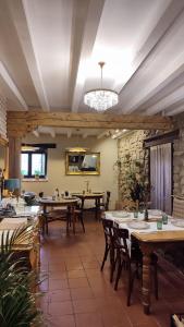 una sala da pranzo con tavoli, sedie e lampadario a braccio di Posada La Dalia a Castillo-Pedroso