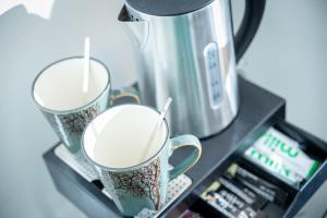 two cups of coffee sitting on top of a microwave at Kings Arms Suites - Luxury Double - Freestanding Bath - Self Check In in Whitehaven