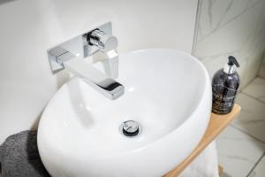 um lavatório branco com uma garrafa numa prateleira em Kings Arms Suites - Luxury Double - Freestanding Bath - Self Check In em Whitehaven