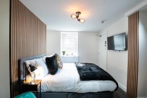a bedroom with a bed and a television on the wall at Kings Arms Suites - Luxury Double - Freestanding Bath - Self Check In in Whitehaven +13 photos