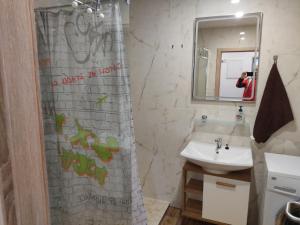 a bathroom with a sink and a shower with graffiti at Malý apartmán v Praze in Prague