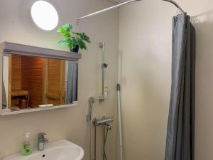 a bathroom with a sink and a shower with a mirror at Tilava 2BR-huoneisto Saunalla in Oulu