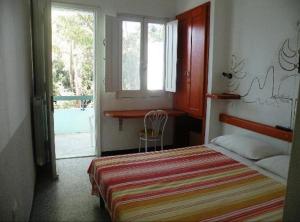 - une chambre avec un lit, une fenêtre et une porte dans l'établissement Hotel Splendor, à Tortolì