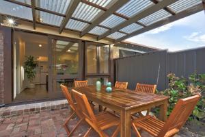 d'une terrasse avec une table et des chaises en bois. dans l'établissement Spacious 3 Bedroom on the edge of Downtown Herford St 2 E-Bikes Included, à Sydney